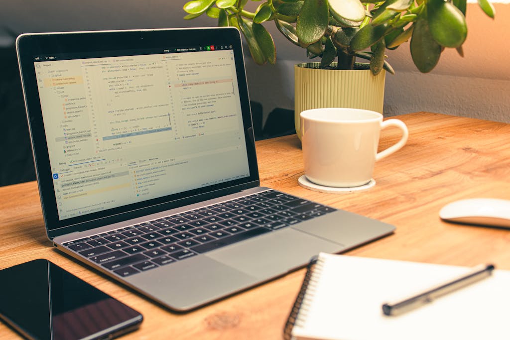 Cozy home office setup featuring a laptop, coffee, and a green plant for productivity.
