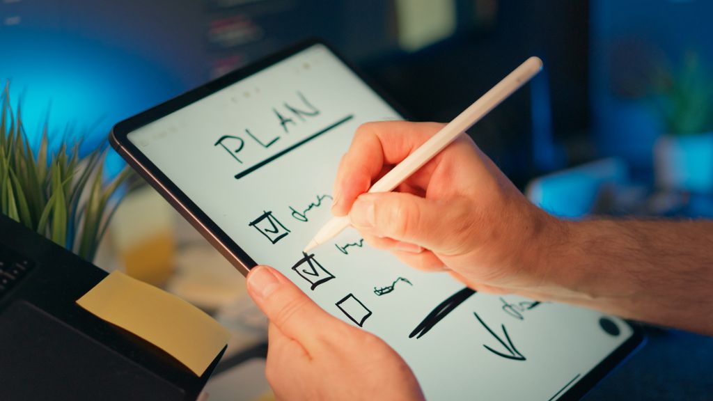 Person writing an action plan during a coaching reflection exercise